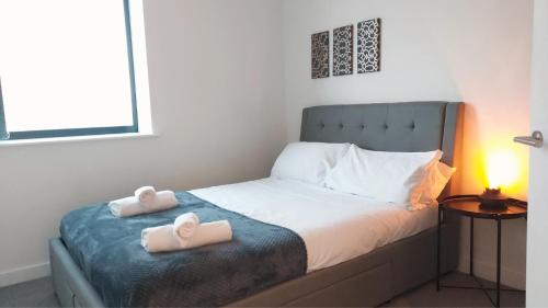 a bedroom with a bed with two towels on it at Stunning one bedroom near Old Trafford Stadium in Manchester