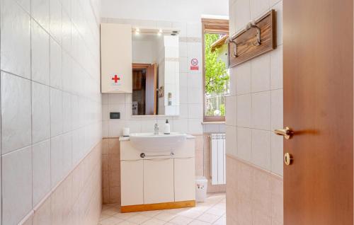 La salle de bains est pourvue d'un lavabo et d'un miroir. dans l'établissement Stunning Home In Bosconero With Kitchen, 
