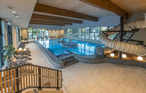 a large swimming pool with a slide in a building at Beach Front Home In Lembruchdümmer See in Lembruch
