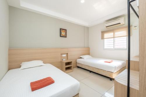 a bedroom with two beds and a window at Bahagia Villa in Kuah