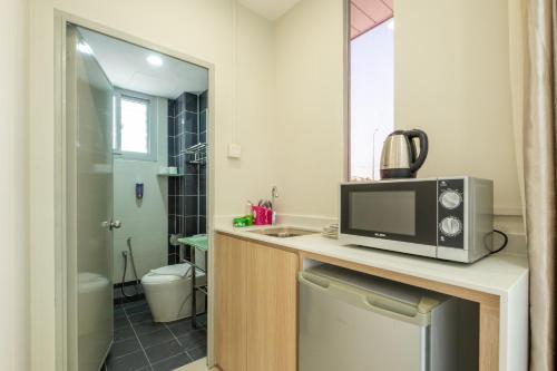 a microwave sitting on a counter in a bathroom at Bahagia Villa in Kuah