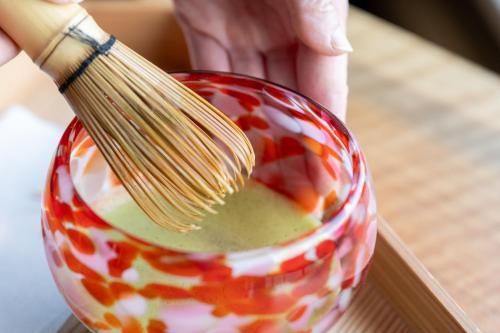 a person holding a whisk in a bowl of food at NISEKO Inn of Youtei Raku Suisan in Kutchan