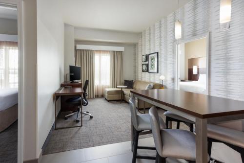 Habitación de hotel con escritorio y comedor en Residence Inn by Marriott Columbus Polaris, en Columbus