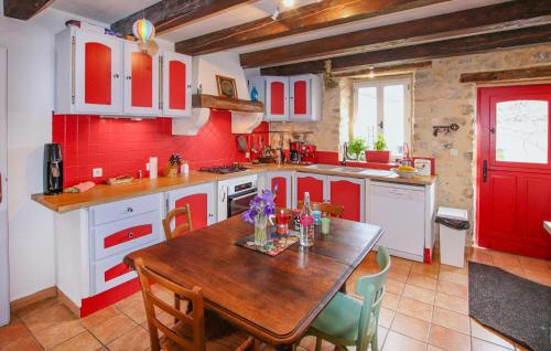 - une cuisine avec une table en bois et des murs rouges dans l'établissement Beautiful Home In Gras, à Gras