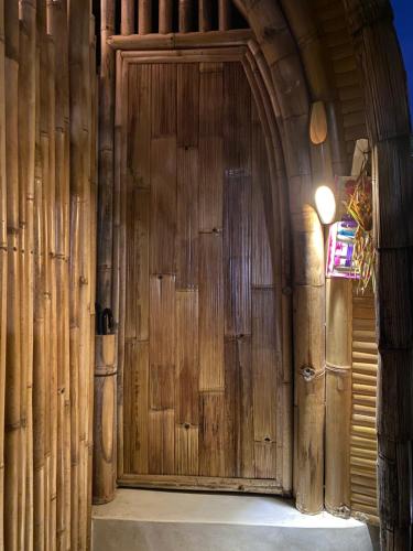 - une grande porte en bois dans un bâtiment en bois dans l'établissement Gladak di Uma Bali, à Sidemen