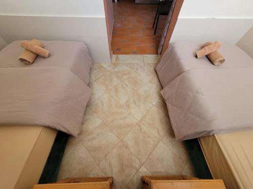 2 camas individuais num pequeno quarto com uma escada em Imi Ouaddar Apartment just Steps from the Beach em Agadir nʼ Aït Sa