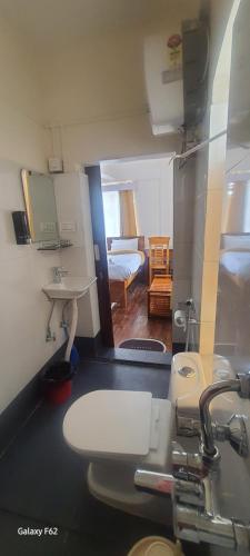 a bathroom with a sink and a toilet in a room at Shree Niwas in Darjeeling