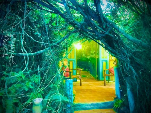 an archway with a table and chairs under a tree at Serendipity Lake Artistic Bungalow by Heidis Home in Nuwara Eliya