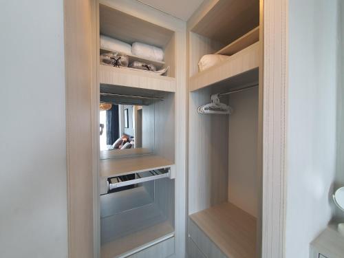 vestidor con estanterías de madera y espejo en prio公寓, en Chiang Mai
