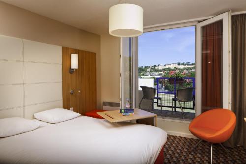 Cette chambre comprend un lit et une fenêtre avec vue. dans l'établissement ibis Styles Chinon, à Chinon
