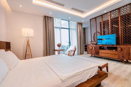 a bedroom with a large bed and a flat screen tv at FLC Grand Villa BT35.06 in Sầm Sơn