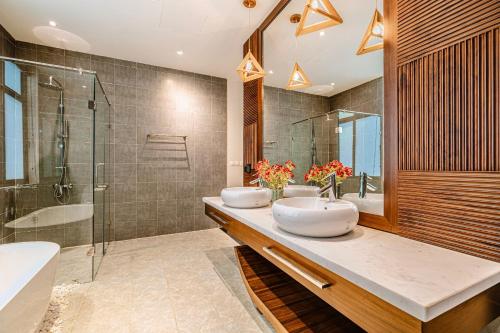 a bathroom with two sinks and a shower at FLC Grand Villa BT35.06 in Sầm Sơn