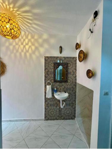 a bathroom with a sink and a mirror at AFRICA SURF HOUSE in Taghazout