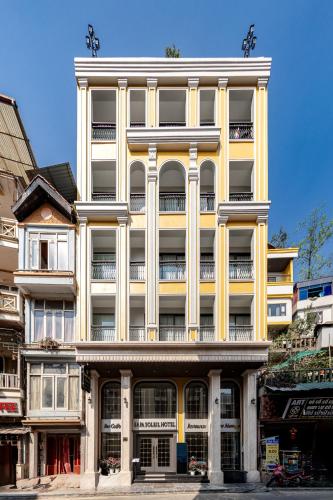 a tall yellow building with a lot of windows at Sapa Soleil Hotel in Sa Pa