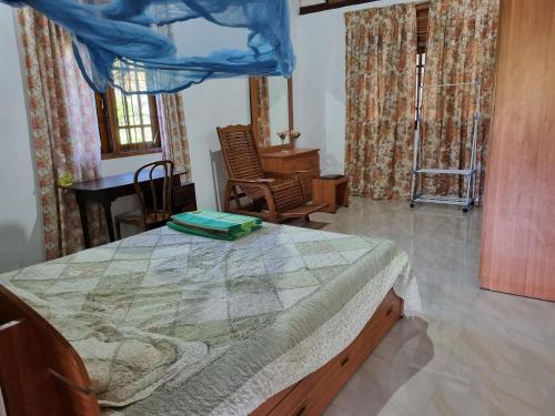 a bedroom with a bed and a table and chairs at Serenity Stay in Badulla