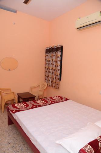 a bedroom with a bed and a table and chairs at SURUkuttyYATRA in Rāmeswaram