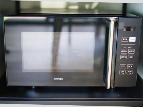a microwave oven with a window on top of it at Rainbow Village（レインボーヴィレッジ） in Mihama