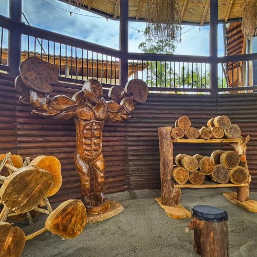 a statue of a man holding a lot of logs at Eden Hotel in El Peñol