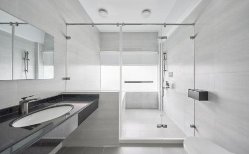 een badkamer met 2 wastafels en een glazen douche bij 像個家plus民宿 AT home plus B&B in Hualien