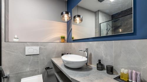 La salle de bains est pourvue d'un lavabo blanc et de placards bleus. dans l'établissement AV apart hotel, à Senec