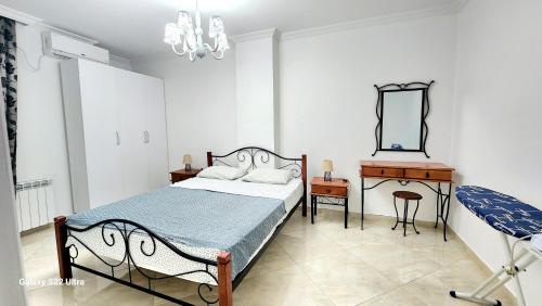 1 dormitorio con cama, escritorio y espejo en Watching The Sea Apartment, en Batumi