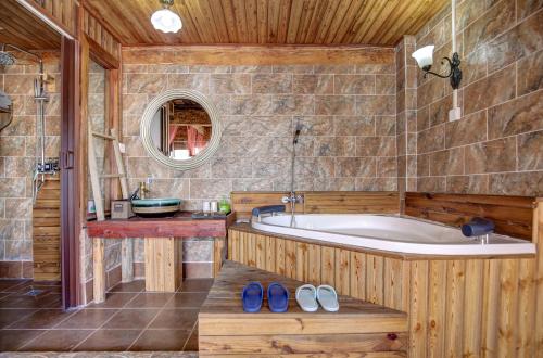 ein Badezimmer mit einer Badewanne, einem Waschbecken und einem Spiegel in der Unterkunft Shangri-La Youran Valley Inn in Shangri-La