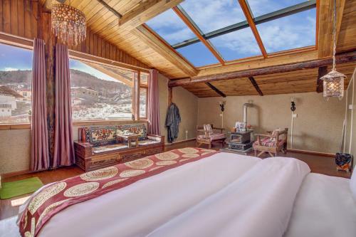ein Schlafzimmer mit einem großen Bett und einem großen Fenster in der Unterkunft Shangri-La Youran Valley Inn in Shangri-La