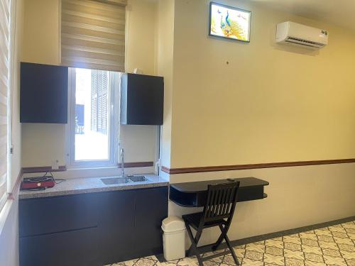 a kitchen with a chair next to a counter and a window at SAM HOMESTAY HUE in Hue