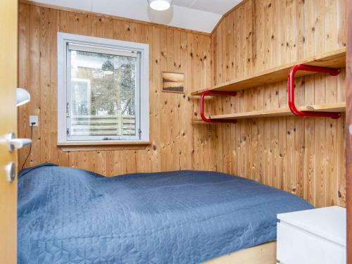 um quarto com uma cama azul e uma janela em Holiday home Struer XXVIII em Struer