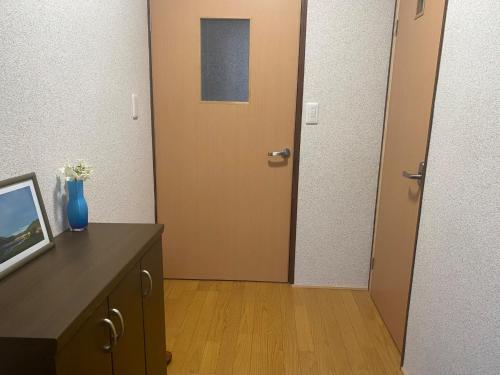 a hallway with a door and a table with a vase of flowers at Gohuku - Vacation STAY 41804v in Kami-ichi