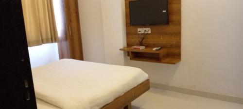 małą sypialnię z łóżkiem i telewizorem w obiekcie Hotel 7star near airport w mieście Indore