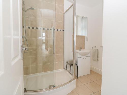 ein Bad mit einer Dusche und einem Waschbecken in der Unterkunft Gables Retreat in Trearddur