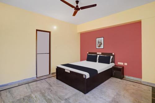- une chambre avec un lit et un ventilateur de plafond dans l'établissement OYO 27 DEGREE HOTEL, à Jamshedpur