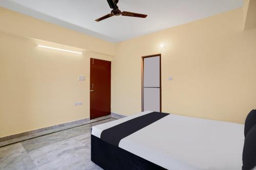 Schlafzimmer mit einem Bett und einem Deckenventilator in der Unterkunft OYO 27 DEGREE HOTEL in Jamshedpur