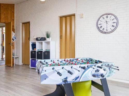 a ping pong table in a room with a clock at 7 person holiday home in Struer in Humlum