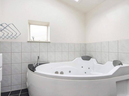 a white bath tub in a bathroom with a window at 7 person holiday home in Struer in Humlum