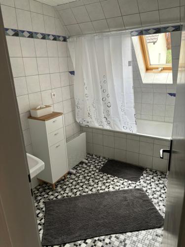 bagno con doccia, vasca e lavandino di Ferienwohnung Alpenblick a Benningen