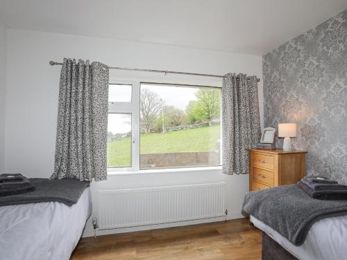 a bedroom with a window with a view of a field at Frondeg in Tregarth