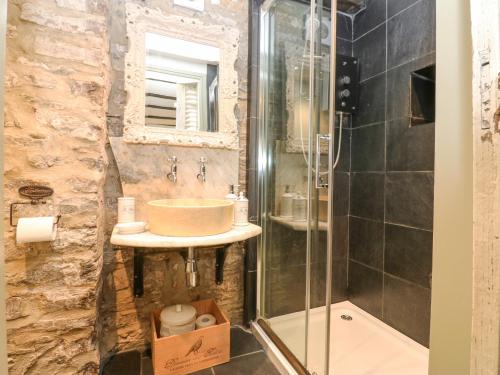 uma casa de banho com um lavatório e um chuveiro em In & Out Cottage em Middleham