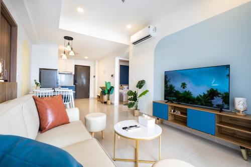 a living room with a white couch and a large screen tv at Lisa Apartment - SOHO Residence in Ho Chi Minh City