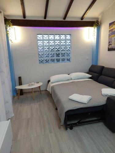a living room with two beds and a couch at Thanos Guesthouse Corfu in Áyioi Dhéka