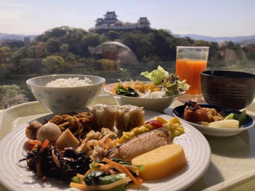 a table with a plate of food and a drink at Smile Hotel Wakayama in Wakayama