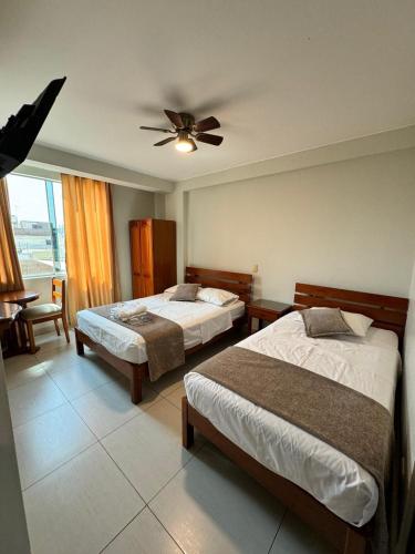 a bedroom with two beds and a ceiling fan at Hotel JOMA in San Vicente de Cañete