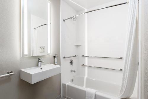 a white bathroom with a sink and a shower at Candlewood Suites Yuma by IHG in Yuma