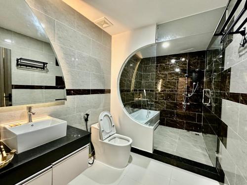 y baño con aseo, lavabo y espejo. en Kep Sea View Hotel & Sky Bar en Kep