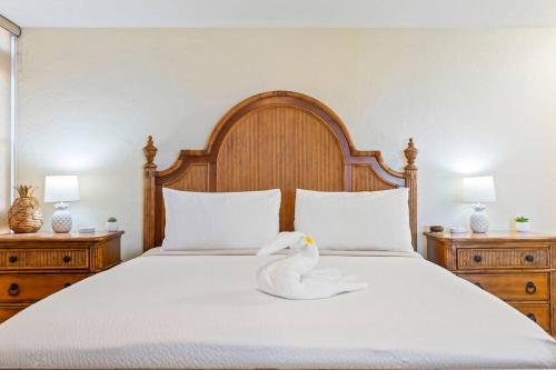 a swan sitting on a bed with two night stands at Nani Kai Hale 209- Remodeled prime oceanfront 1 bedroom Kihei gem in Kihei
