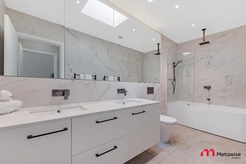 a white bathroom with two sinks and a shower at MetaWise Luxury Haven 4 Bed in Central Double Bay in Sydney