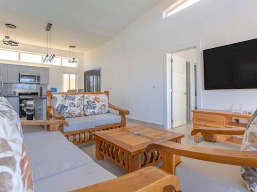 a living room with couches and a flat screen tv at Caribbean Paradise Villa - 3 bed, 3 Bath and Pool in Sosúa