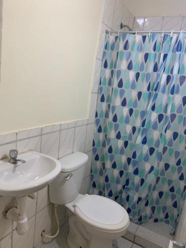 een badkamer met een toilet en een douchegordijn bij Casa Wong in Iquitos