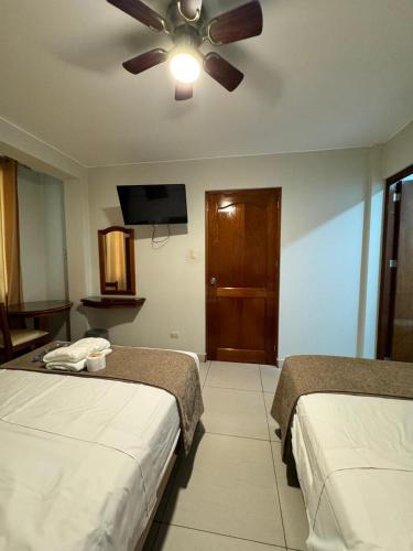 a hotel room with two beds and a ceiling fan at Hotel JOMA in San Vicente de Cañete